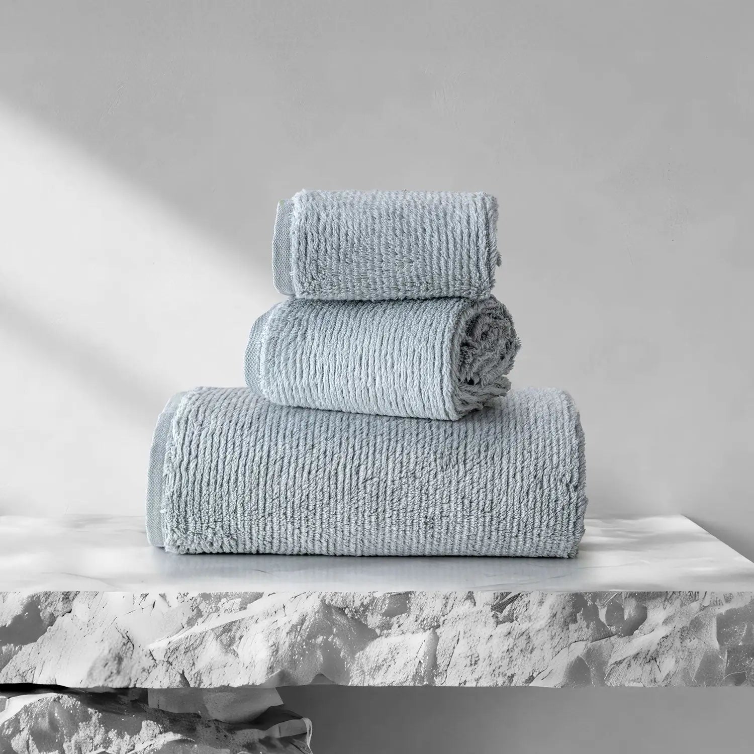 Earth Cotton 3-piece silver towel set – 100% cotton towels folded on stone surface
