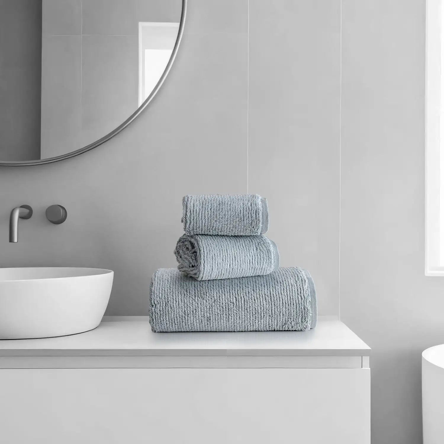 Earth Cotton 3-piece silver towel set – 100% cotton towels stacked beside wash basin