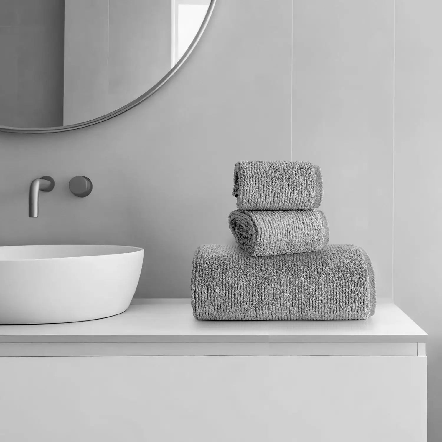 Earth Cotton 3-piece stone towel set – 100% cotton towels stacked beside wash basin